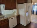 Well-equipped kitchen with modern dishwasher, stainless sink, and white refrigerator, great for cooking and storage at 514 7Th S St, Dundee, FL 33838