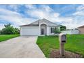 Inviting home exterior showcasing a concrete driveway and well-maintained landscaping at 5424 Moon Valley Dr, Lakeland, FL 33812