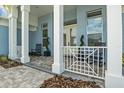 Charming front porch with white railings, rocking chairs, and elegant landscaping at 545 Pond Cypress Ct, Auburndale, FL 33823