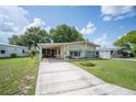 Welcoming single-story home with a pristine driveway, covered parking, and professionally landscaped front yard at 6027 Grand Oaks Se Dr, Winter Haven, FL 33884