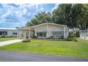 Charming single-story home with a well-manicured lawn, complemented by mature trees and a convenient carport at 6027 Grand Oaks Se Dr, Winter Haven, FL 33884