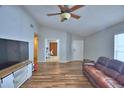 Bright and airy living room showcasing hardwood floors, ceiling fan, and a view into an adjacent room at 658 Lake Dexter Cir, Winter Haven, FL 33884