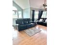 Spacious living room with hardwood floors, neutral paint, large windows, and a comfortable leather sofa at 7906 Waterview Way # 7906, Winter Haven, FL 33884