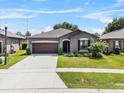 Well-kept home with a two-car garage, attractive landscaping, and a welcoming front entrance at 8720 Micmac Ct, Polk City, FL 33868