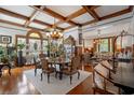 Elegant dining room featuring a coffered ceiling, hardwood floors, and a grand chandelier at 103 Se Tuscawilla Ave, Ocala, FL 34471