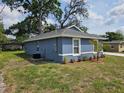 Exterior view of the home showcasing its blue siding, and well maintained surroundings and green lawn at 1121 W 9Th St, Lakeland, FL 33805