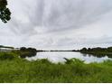 Scenic view of the tranquil pond, reflecting the cloudy sky above at 1264 Buckeye Ne Rd, Winter Haven, FL 33881