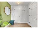 Stylish entryway with a round mirror, storage ottoman and wood-look flooring at 1274 Pintail Pl, Lakeland, FL 33813