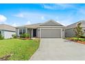 Inviting home featuring a manicured lawn and a driveway leading to a two-car garage at 1274 Pintail Pl, Lakeland, FL 33813