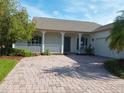 Inviting home featuring a brick driveway and a charming porch with columns at 130 Prima Dr, Kissimmee, FL 34759