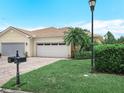 Charming single-Gathering home featuring a well-maintained lawn, landscaping and a brick paver driveway at 1349 Innsbruck Ct, Winter Haven, FL 33884