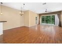 Open-concept living room with laminate floors, ceiling fan and large sliding glass doors leading to the backyard at 1349 Innsbruck Ct, Winter Haven, FL 33884