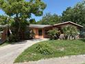 Inviting single-story home showcasing a well-maintained front lawn, mature trees, and a cozy entryway at 1506 Fairbanks St, Lakeland, FL 33805