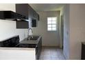 Efficient kitchen with grey cabinetry, black appliances, and a double stainless steel sink at 1506 Fairbanks St, Lakeland, FL 33805