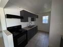 Efficient kitchen with grey cabinetry, black appliances, and a double stainless steel sink at 1506 Fairbanks St, Lakeland, FL 33805