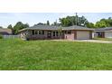 Attractive brick home with a lush green lawn and attached garage at 165 Lagoon Rd, Winter Haven, FL 33884