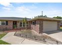 Quaint brick home featuring an attached garage and meticulous landscaping at 165 Lagoon Rd, Winter Haven, FL 33884