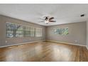 Spacious living room featuring hardwood floors, a ceiling fan, and large windows offering ample natural light at 208 Lake Dale Dr, Auburndale, FL 33823