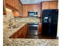 Updated kitchen featuring granite countertops, stainless steel appliances, and custom wood cabinets at 217 Shore Loop, Winter Haven, FL 33884