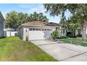 Side view of a well-maintained single-story home with attached garage and green lawn at 2505 Brownwood Dr, Mulberry, FL 33860