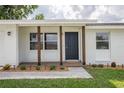 Inviting front entrance with a dark colored front door framed by wood columns and fresh landscaping at 4921 Sharon Ave, Lakeland, FL 33812