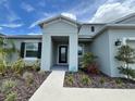 Charming home entrance with meticulous landscaping and walkway to the front door at 516 Ingleside Ln, Haines City, FL 33844