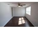 Bright living room featuring dark hardwood floors, neutral wall color, and a ceiling fan at 520 Oakland Rd, Auburndale, FL 33823