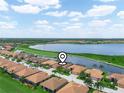 Beautiful aerial view of homes in a lakeside community with lush green spaces and a tranquil lake at 5200 Pebble Beach Blvd, Winter Haven, FL 33884