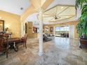 Elegant living room with decorative columns, travertine floors, and access to an outdoor patio at 5200 Pebble Beach Blvd, Winter Haven, FL 33884