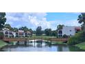 Picturesque view of a wooden bridge spanning a serene pond with building in the background at 7201 Country Club Dr # G21, Lake Wales, FL 33898