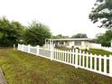 Well-kept front yard with a white picket fence and view of the home at 7814 Plunkett Ave, Orlando, FL 32810