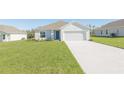 Well-maintained one-story home with a spacious front yard and a long driveway leading to the garage at 2173 Emma Ln, Lake Wales, FL 33859