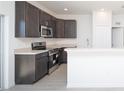 Modern kitchen with stainless steel appliances and dark brown cabinets at 322 Brennan Ave, Frostproof, FL 33843
