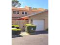 Exterior view of townhouse with two-car garage, neutral stucco, tidy landscaping, and brick-paved driveway at 1019 Grove St # 85, Maitland, FL 32751