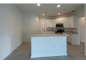 Modern kitchen featuring white cabinetry, stainless steel appliances, and a breakfast bar at 227 Bryce Ln, Frostproof, FL 33843