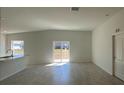 Bright, open-concept living room with tile flooring and sliding glass doors to the backyard at 216 Harper Estates Cir, Lake Wales, FL 33859