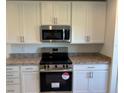 Modern kitchen featuring white cabinetry, stainless steel appliances, and stylish countertops at 221 Harper Estates Cir, Lake Wales, FL 33859