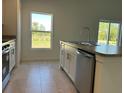 Well-lit kitchen boasts stainless steel appliances, a tile floor, and a view of the outdoors at 221 Harper Estates Cir, Lake Wales, FL 33859
