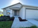 Attractive home showcasing a covered front porch and landscaped garden beds leading to the entry at 2181 Emma Ln, Lake Wales, FL 33859