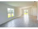 Bright living room with neutral tile flooring, natural light, and sliding glass doors at 2181 Emma Ln, Lake Wales, FL 33859