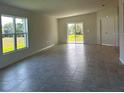 Spacious living room with tiled floors, large windows and glass sliding doors to a lawn at 2181 Emma Ln, Lake Wales, FL 33859