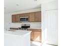 Modern kitchen features stainless steel appliances, wood cabinets, and bright countertops at 2203 Carson Loop, Lake Wales, FL 33859