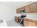 Modern kitchen features stainless steel appliances, wood cabinets, and bright countertops at 2203 Carson Loop, Lake Wales, FL 33859