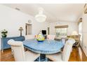 Open concept dining area featuring a blue table and hardwood floors at 2605 Seneca Ave, The Villages, FL 32162