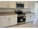 Modern kitchen with stainless steel appliances and white cabinets at 416 Central Ave, Frostproof, FL 33843