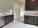 Well-lit kitchen featuring dark wood cabinetry, stainless steel appliances, tile flooring, and open floor plan at 422 Central Ave, Frostproof, FL 33843