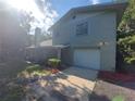 Green house with white garage door and landscaping at 253 N Blue Lake Ave, Deland, FL 32724