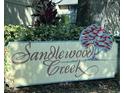 Community sign reading Sandlewood Creek surrounded by greenery, adding a welcoming touch to the neighborhood at 255 Sandlewood Trl # 4, Winter Park, FL 32789