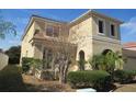 View of the side of the house shows windows, professional landscaping, and a well maintained stucco exterior at 2802 Quiet Water Trl, Kissimmee, FL 34744