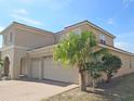 Attractive home with a three-car garage, tile roof, arched entryway and decorative shrubbery at 2802 Quiet Water Trl, Kissimmee, FL 34744